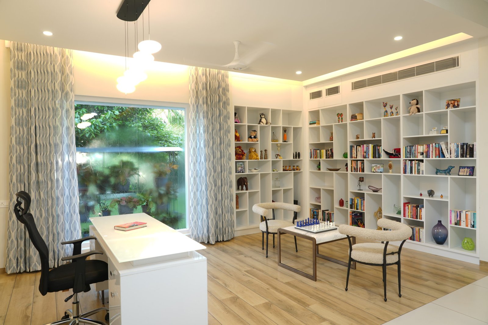 Home study with full-wall white bookshelves