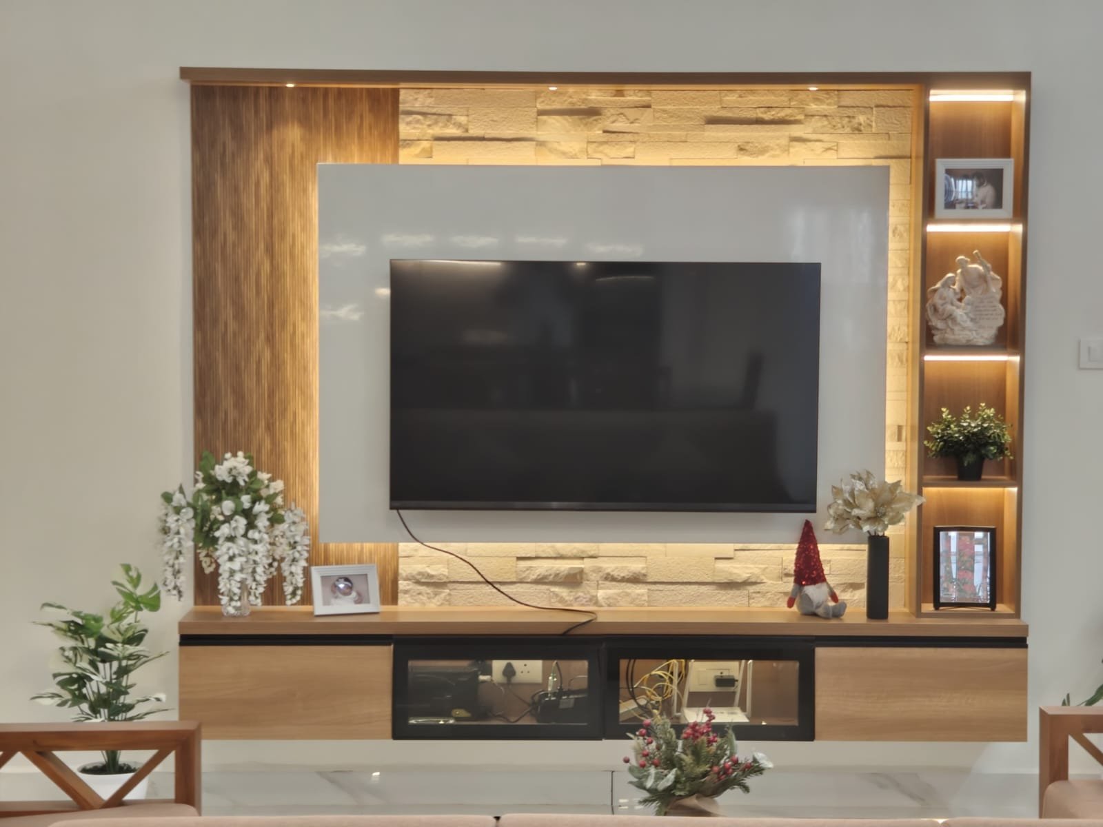 Living room with backlit shelving and stone feature wall